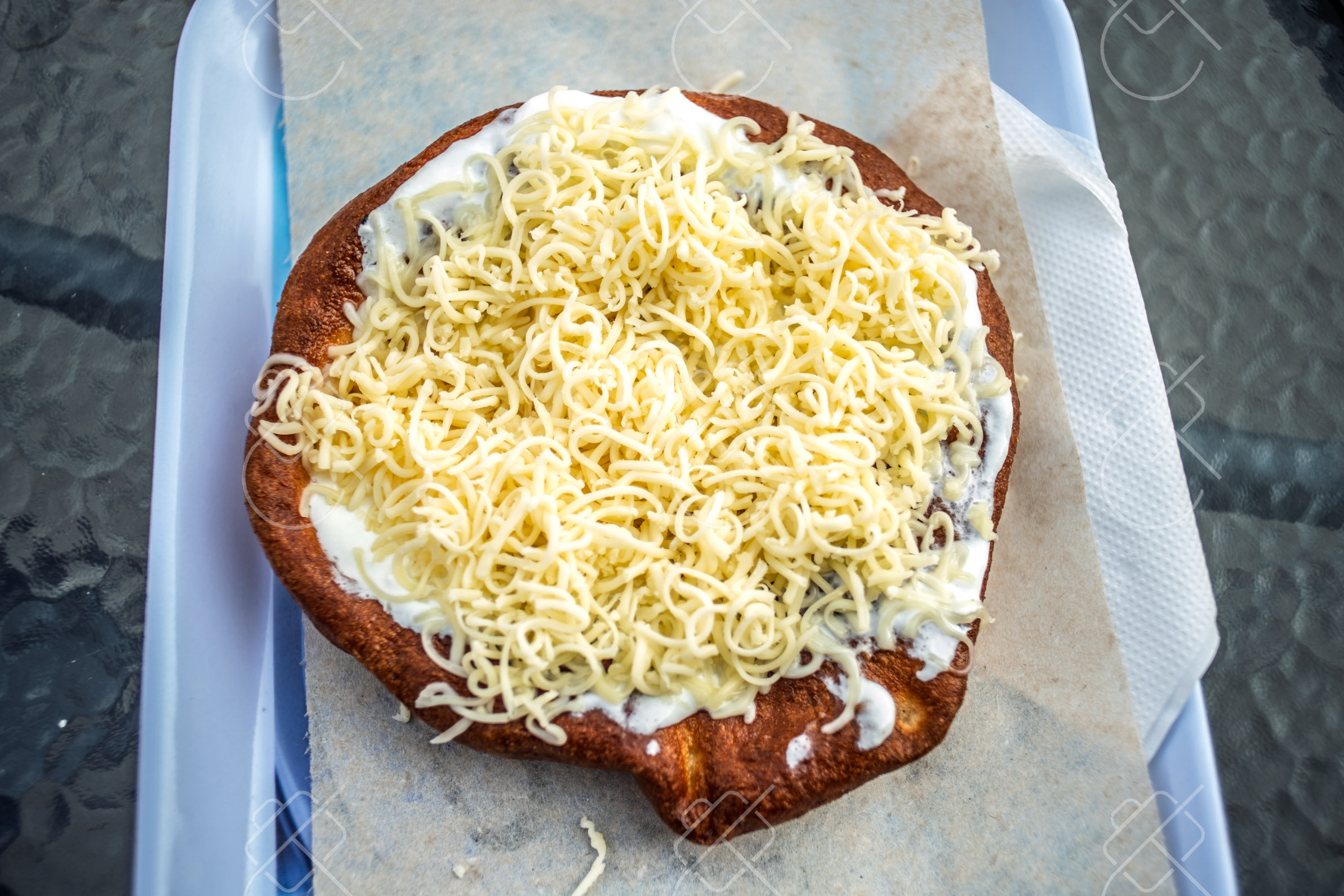 Lángos (Hungarian fried dough) with sour cream and cheese — Central Europe