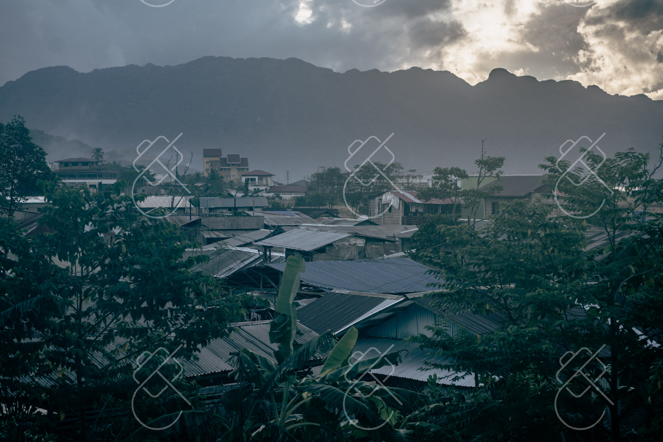 Coron town's rooftops at dusk, karst hills behind — Coron, fine art travel photography print available from Clever Tourists