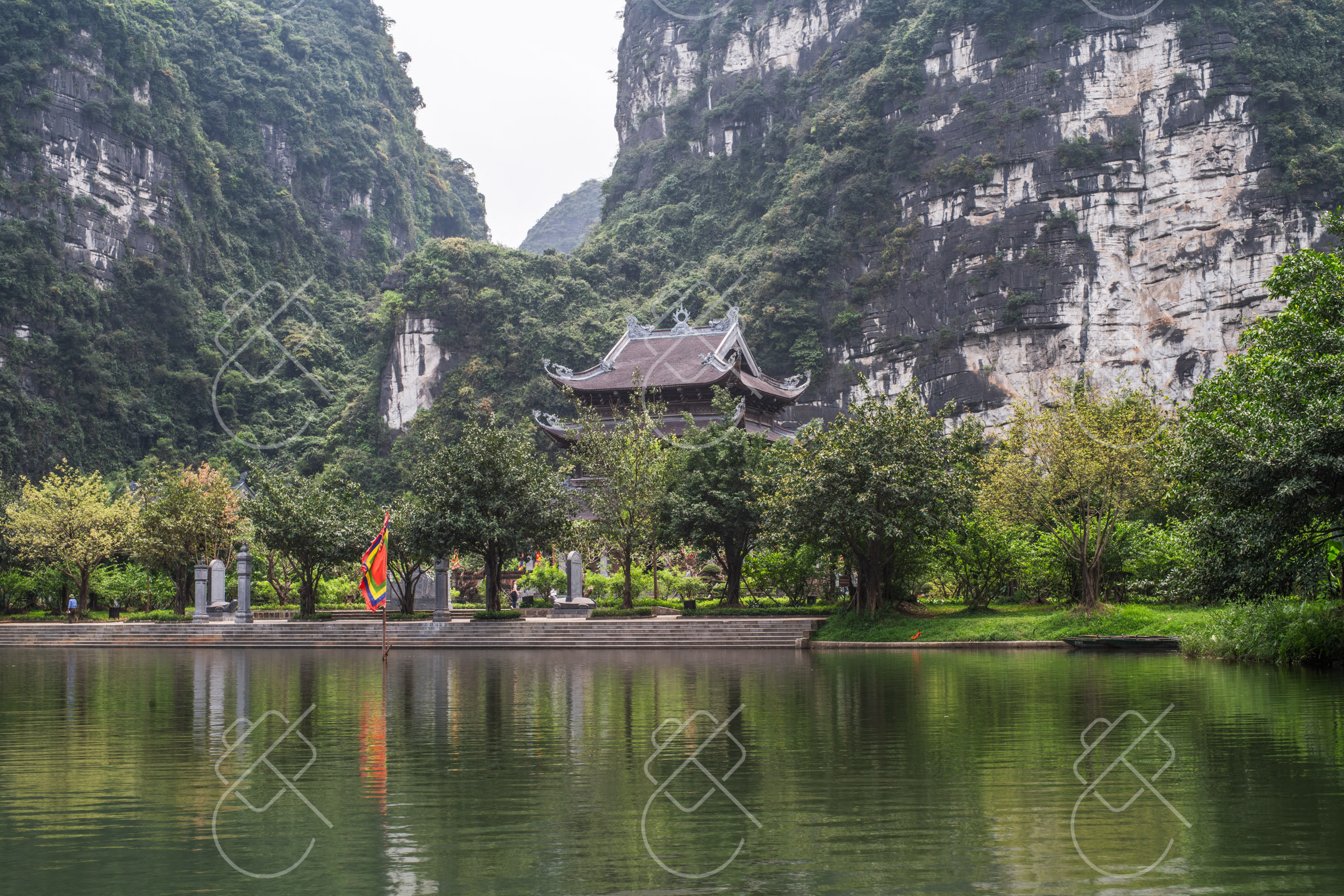 Temple architecture set directly against the limestone cliffs — Trang An & Hoa Lu, fine art travel photography print available from Clever Tourists