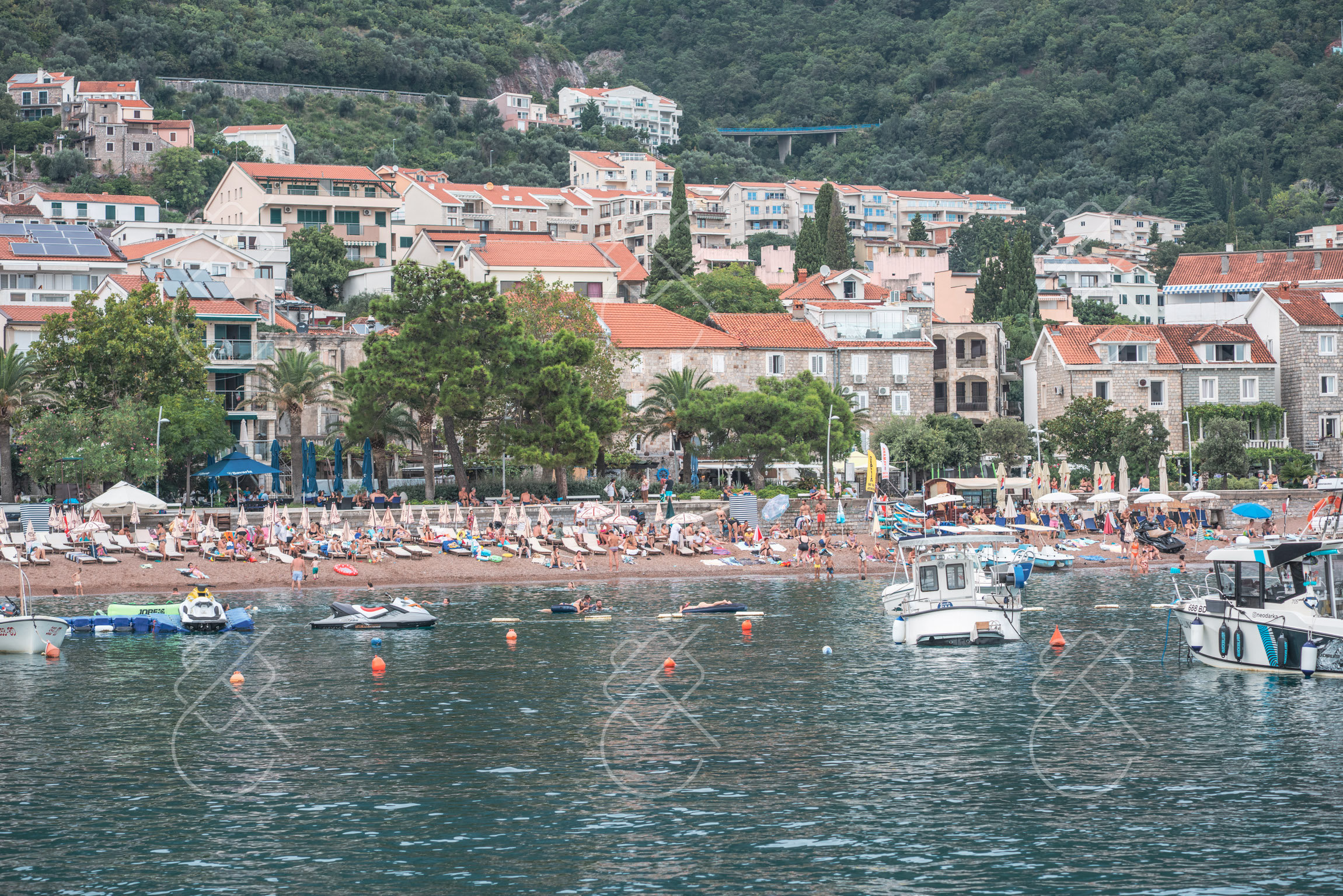 Petrovac's crescent beach and terracotta rooftops seen from the water — Petrovac, fine art travel photography print available from Clever Tourists